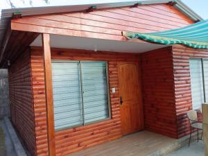 a wooden cabin with a door and a deck at Cozy cabin for 4 people San Pedro de Atacama in San Pedro de Atacama