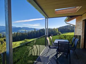 a patio with a table and chairs on a balcony at Weitblickhof Roth in Sulzberg