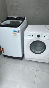 a white washing machine sitting next to a washer at Casa com piscina in Tramandaí