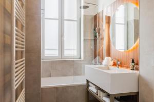 une salle de bains avec un lavabo et un miroir dans l'établissement FortyPlusOne Apartments Vienna, à Vienne 17 autres photos