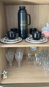 a wooden shelf with glasses and a tea pot on it at Casa com piscina in Tramandaí
