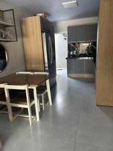 a kitchen with a refrigerator and a table and chairs at Casa com piscina in Tramandaí +1 photo