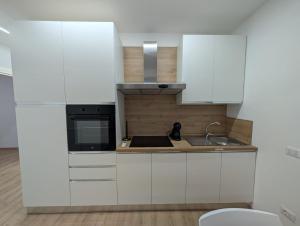 a kitchen with white cabinets and a sink at Inn Puglia Guest House 2 in Acquaviva delle Fonti +24 photos