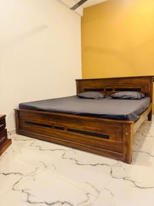 een bed met een houten frame in een kamer bij Madinah Comfort Inn in Colombo
