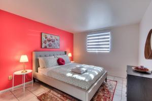 a bedroom with a bed with a red wall at Spacious 2BR ! 6 guest Vacation home Montreal in Montréal +12 photos