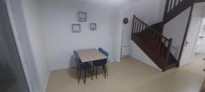 Una mesa y sillas en una habitación con escalera. en Les terrasses de Gravelines, en Gravelines 5 fotos más