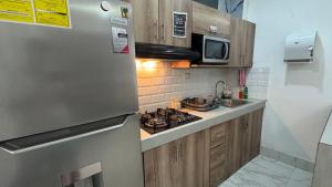 a kitchen with a stainless steel refrigerator and a sink at La Posada De Don Jose in Flores