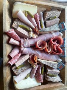 a wooden tray filled with different types of meats and cheeses at gîte romantique in Etalondes-la-Pipe +8 photos