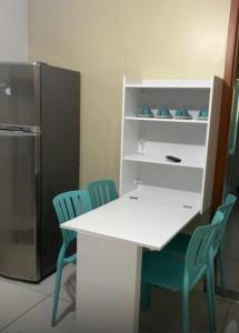 una cucina con tavolo e sedie bianchi e frigorifero di ISRAEL FLAT TAMBAÚ - 102 a João Pessoa