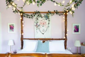 a bedroom with a canopy bed with flowers on it at The Dragonfly Inn in Launceston