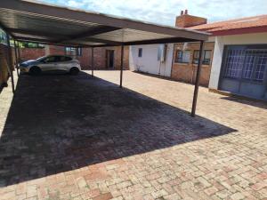 een garage met een auto geparkeerd onder een dak bij Manor Rentals in Potchefstroom