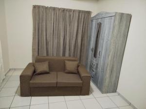 een woonkamer met een bank en een kast bij Manor Rentals in Potchefstroom