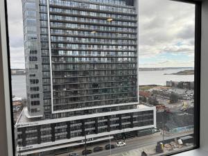 Blick auf ein großes Gebäude aus dem Fenster in der Unterkunft Waterfront 1 BR corner unit - 6 appliances & gym in Halifax