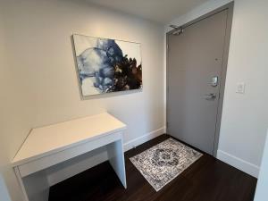 ein Raum mit einem Tisch und einem Gemälde an der Wand in der Unterkunft Waterfront 1 BR corner unit - 6 appliances & gym in Halifax