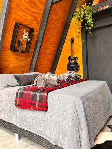 une chambre avec un lit avec une couverture et une guitare dans l'établissement Constelacaodachapada, à Ibicoara