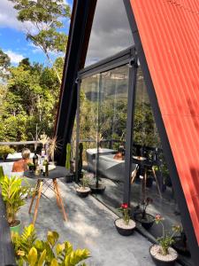 une terrasse extérieure avec baignoire, tables et plantes dans l'établissement Constelacaodachapada, à Ibicoara