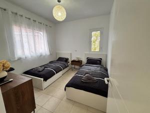 a bedroom with three beds and a table and a window at Large apartment in an idyllic complex, ocean view in Mandria +18 photos