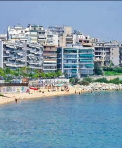 een groep mensen op een strand met gebouwen bij Carolos‘ house in Kavala