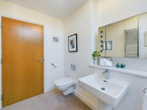 um banheiro com uma pia, um vaso sanitário e um espelho em Turfhill House em New Deer