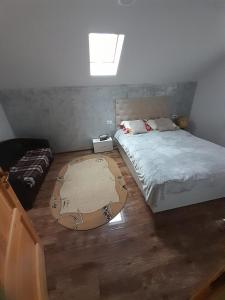 a bedroom with a bed and a rug on the floor at Casa de vacanta Gea in Dobra