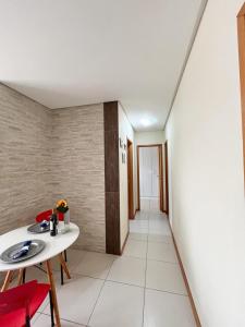 a room with a table and chairs and a hallway at Apto com Estilo e Conforto no Centro in Petrolina