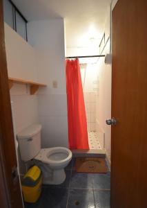y baño con aseo y cortina de ducha roja. en The Chusay Home, en Abancay