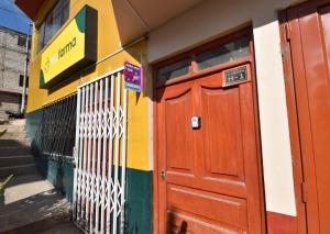 Un edificio colorido con una puerta roja en una calle. en The Chusay Home, en Abancay