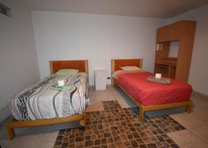 1 dormitorio con 2 camas y 1 cama roja en The Chusay Home, en Abancay