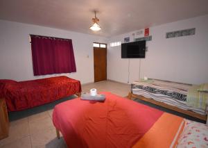 Una habitación con dos camas y un televisor de pantalla plana. en The Chusay Home, en Abancay