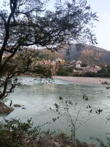 a view of a river with a city in the background at Solo Nari Backpackers Rishikesh in Narendranagar