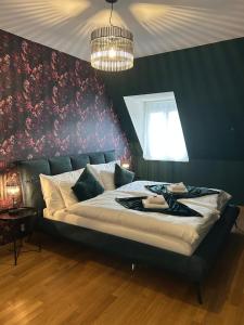 a bedroom with a large bed with a floral wall at Maisonette am Bodensee - Parking - Hoher Komfort in Rorschach +23 photos