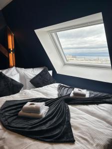 a bed with towels on it with a window at Maisonette am Bodensee - Parking - Hoher Komfort in Rorschach