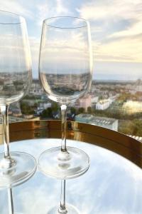 due bicchieri da vino seduti su un tavolo di fronte a una finestra di Luksusowy apartament z widokiem, basenem i sauną Hanza Tower a Stettino Altre 53 foto