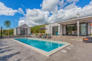 a house with a swimming pool in front of a house at Holiday House Omis - Naklice in Omiš