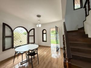 comedor con mesa, sillas y escaleras en Pousada Dona Lidia Express, en Campo Mourão