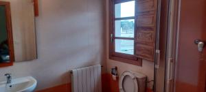 un bagno con un water, un lavandino e una finestra di Pensión San Cristóbal by Bossh! Hotels a Cuenca