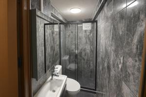 a bathroom with a shower and a sink and a toilet at Grand Sezgin Hotel in Istanbul +42 photos