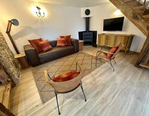 Una sala de estar con un sofá y un televisor. en Casas da Casa do Telhô, en Celorico de Basto