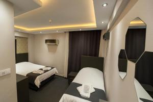 a hotel room with two beds and a mirror at Grand Sezgin Hotel in Istanbul