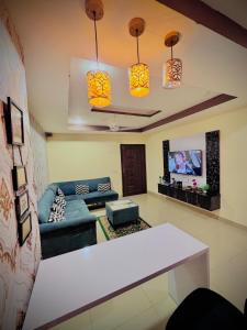The Diplomat Suites Bahria Town في روالبندي: غرفة معيشة مع أريكة وتلفزيون