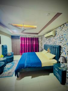 The Diplomat Suites Bahria Town في روالبندي: غرفة نوم بسرير ازرق واريكة +11 صورة