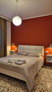 a bedroom with a large bed with a red wall at La Casa di Athina in Celano