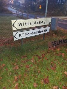 a street sign in the grass next to a street at Selmas Pensionat in Vittsjö