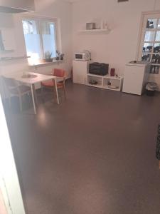 a living room with a table and a kitchen at Selmas Pensionat in Vittsjö