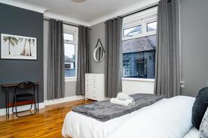 エディンバラにあるLuxury 5BD, Gym, Parking, Bus to Airport, Sleeps10の白いベッドと窓のある寝室