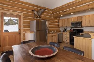 a kitchen with a table with a bird on the ceiling at Powder Ridge Cabin - 9A Red Cloud in Big Sky
