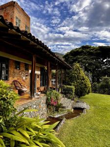 Santa Elena Ventanas Parapente Bed and Breakfast Premium في Santa Helena: منزل من الطوب مع فناء وحديقة