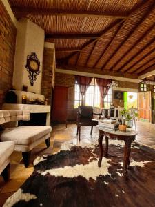 Santa Elena Ventanas Parapente Bed and Breakfast Premium في Santa Helena: غرفة معيشة مع طاولة ومدفأة