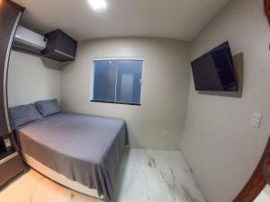 a small bedroom with a bed and a window at Aloha flats in Marechal Deodoro