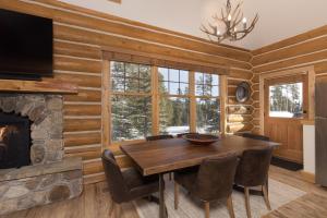 a dining room with a table and a fireplace at Powder Ridge Cabin - 9A Red Cloud in Big Sky